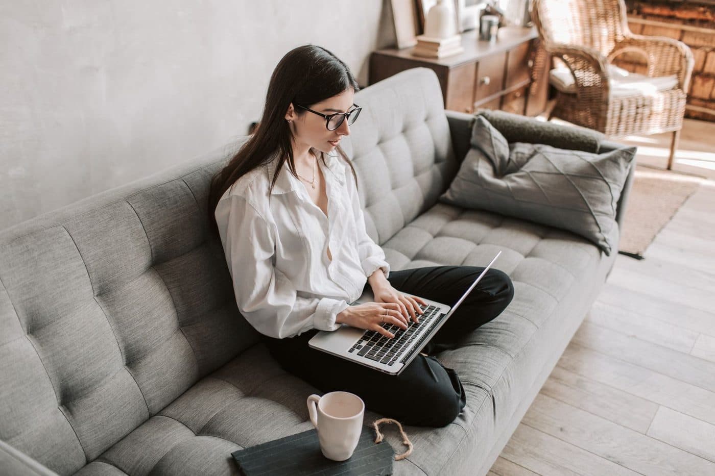 Low laptop work on a sofa that forces a downward gaze