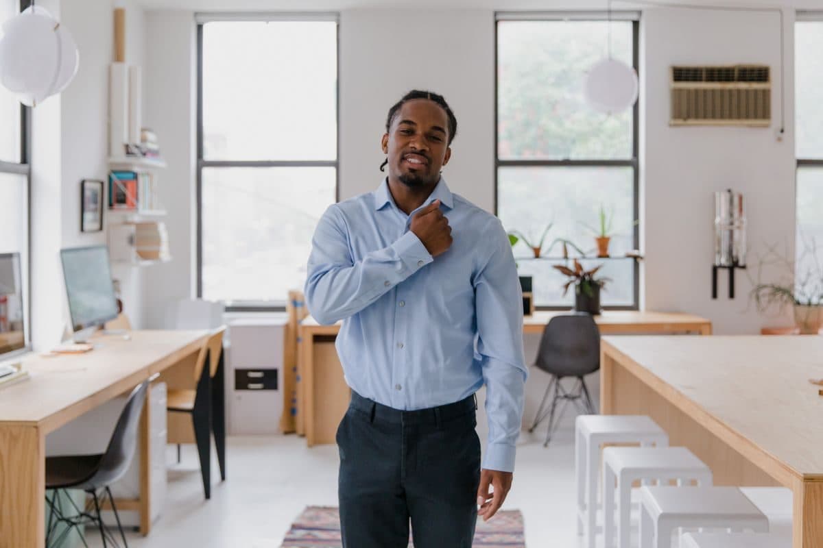 Office worker standing away from a desk chair in a bright workspace