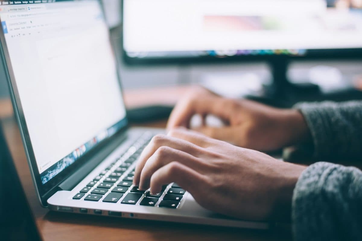 Person working on a laptop at a desk in a focused session