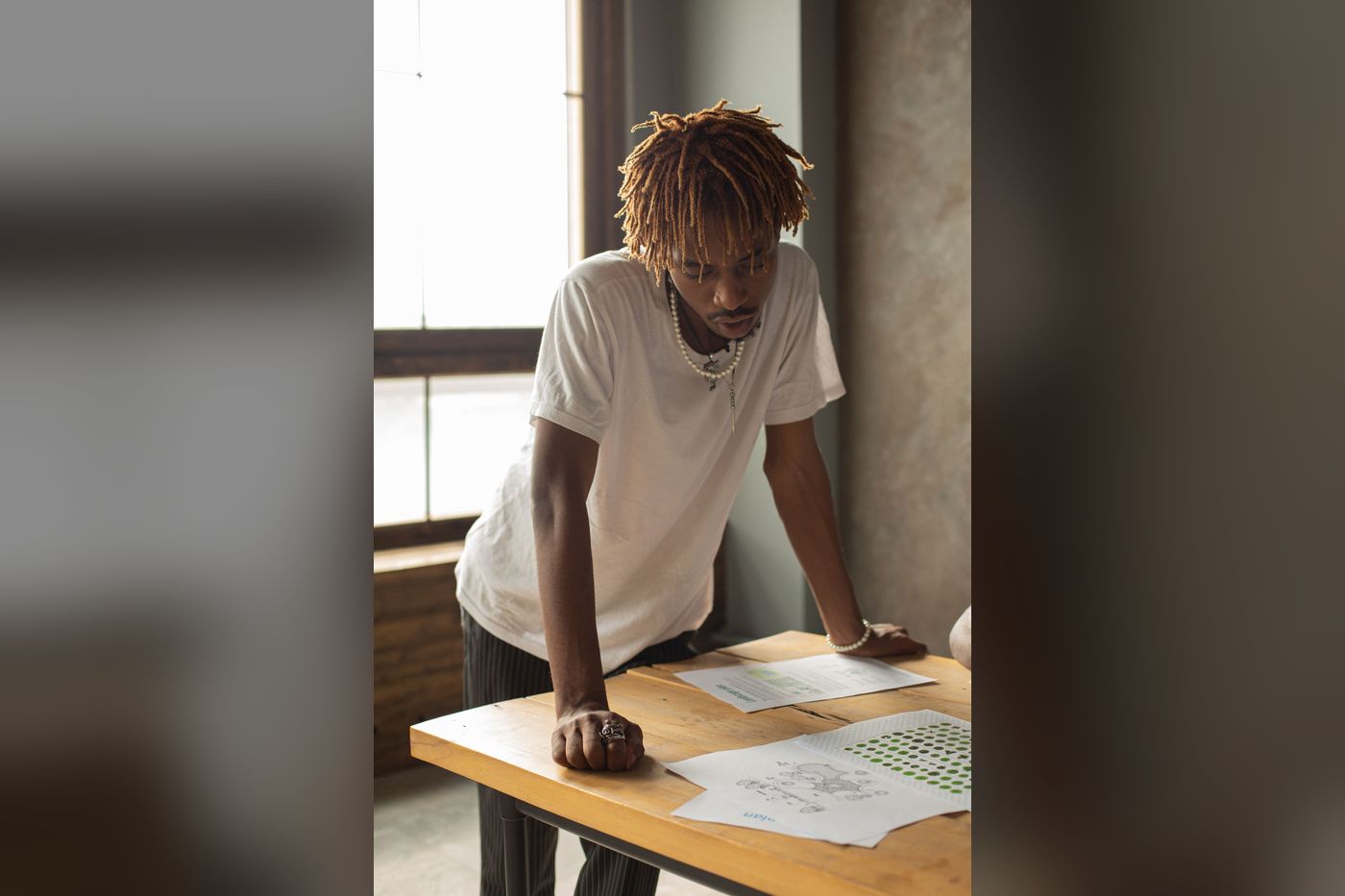 Man leaning forward on his arms over a desk that is too low for standing work