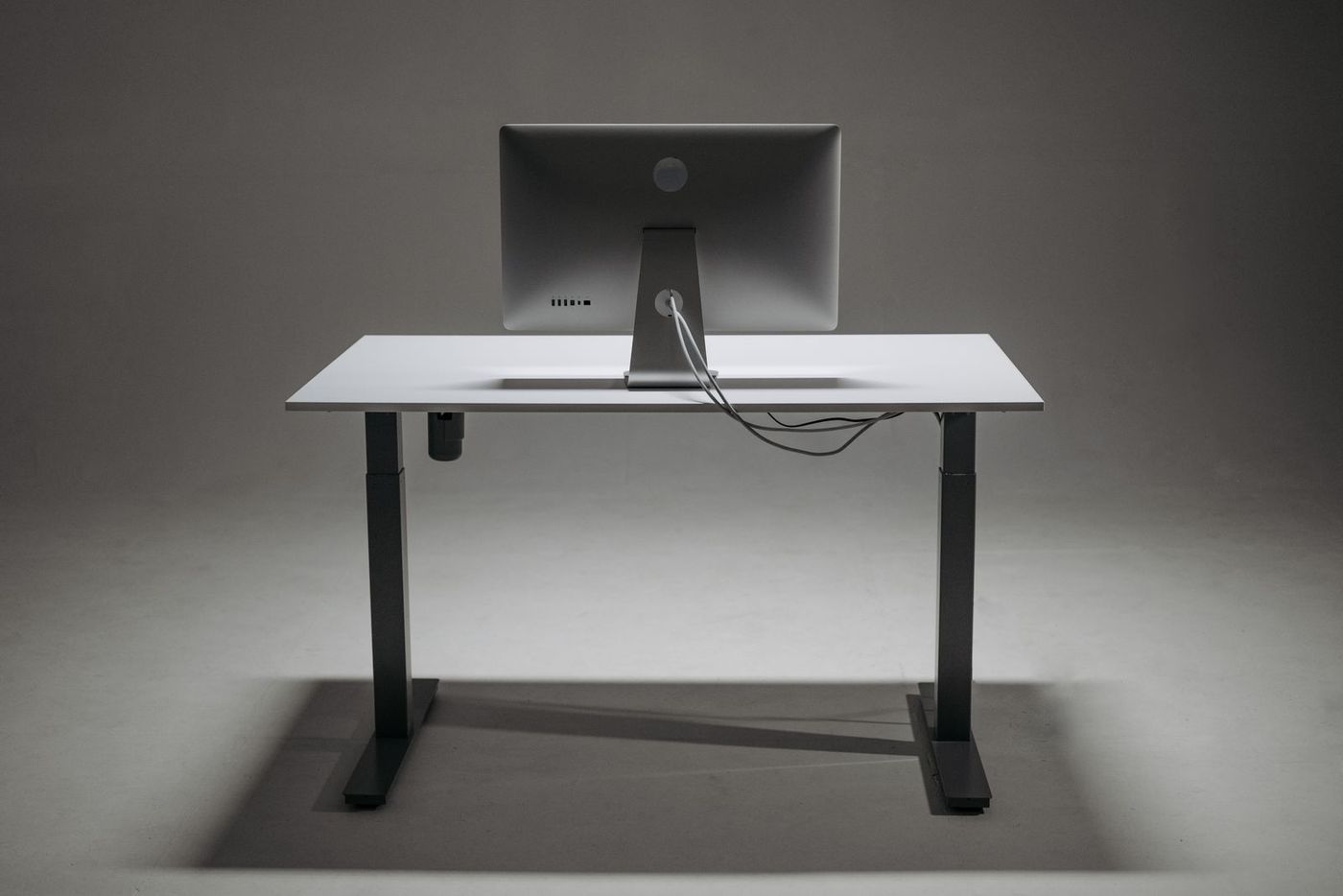 Computer monitor on a height-adjustable desk with tidy cable management